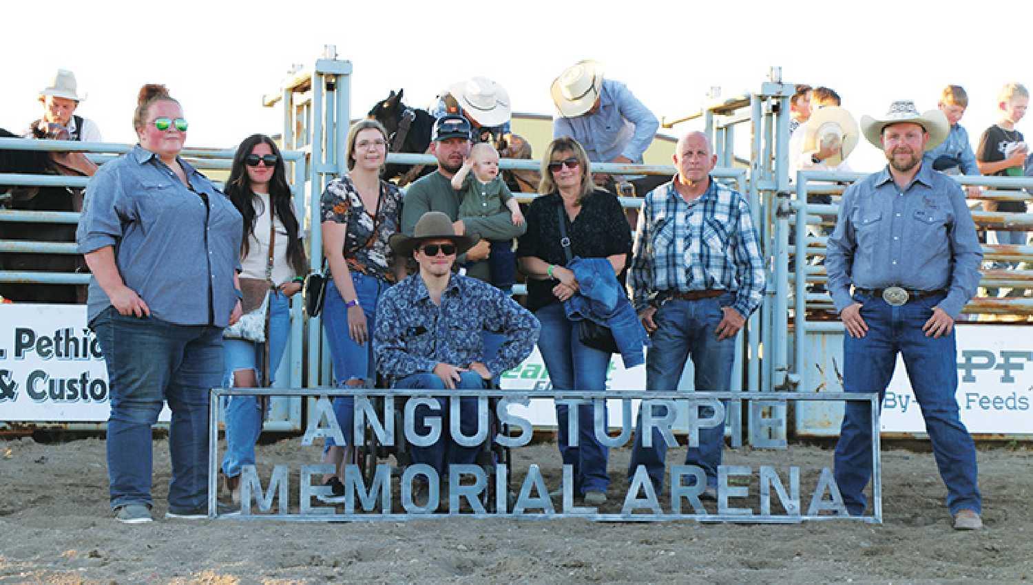 The presentation at Bulls & Broncs on July 13 to rename the Moosomin rodeo arena after Angus Turpie. From left are Chelan Beckett with the Moosomin Rodeo Committee, Rylee Schmidt, Meagan Jamieson, Devon Jamieson (holding Myla), Diane Jamieson, Darcy Jamieson, and Mike Sidoryk with the Moosomin Rodeo Committee.